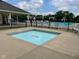 Hot tub next to a community pool with lounge chairs and fencing for safety and relaxation at 7356 Woodington Pl, Indianapolis, IN 46259