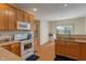 Traditional kitchen with wood cabinets and white appliances alongside a breakfast nook at 7356 Woodington Pl, Indianapolis, IN 46259