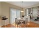 Kitchen eat-in area with white table near sliding glass door and view to fireplace in adjacent room at 7356 Woodington Pl, Indianapolis, IN 46259