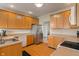 Traditional kitchen with wood cabinets, stainless steel refrigerator, and a kitchen sink at 7356 Woodington Pl, Indianapolis, IN 46259