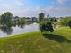 Scenic view of a tranquil pond with a central fountain, framed by grassy shores and neighborhood trees at 7356 Woodington Pl, Indianapolis, IN 46259