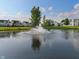 Scenic view of a pond with a fountain surrounded by homes in a well-maintained community at 7356 Woodington Pl, Indianapolis, IN 46259