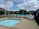 Community pool area featuring a hot tub and pool with lounge chairs and a safety fence at 7356 Woodington Pl, Indianapolis, IN 46259