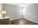 Cozy bedroom features wood floors, natural light from the window, and neutral paint at 7414 Harbour, Indianapolis, IN 46240