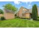 Charming exterior view features lush landscaping, a well-manicured lawn, and a detached garage at 7414 Harbour, Indianapolis, IN 46240