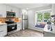 Bright kitchen featuring modern appliances, white cabinets, and a cozy window seat at 7414 Harbour, Indianapolis, IN 46240