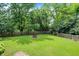 Landscaped backyard with lush green grass, trees, and fire pit at 7720 Langwood Dr, Indianapolis, IN 46268