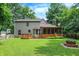 Large backyard with wooden deck, enclosed sunroom, and fire pit at 7720 Langwood Dr, Indianapolis, IN 46268