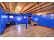 Finished basement with wood look floors, exposed ceiling, and blue painted walls at 7720 Langwood Dr, Indianapolis, IN 46268