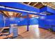 Finished basement with wood look floors, exposed ceiling, and blue painted walls at 7720 Langwood Dr, Indianapolis, IN 46268