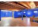 Finished basement with wood look floors, exposed ceiling, and blue painted walls at 7720 Langwood Dr, Indianapolis, IN 46268