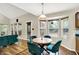 Breakfast nook with a wood table and teal chairs, offering tranquil backyard views, beside the main living area at 7720 Langwood Dr, Indianapolis, IN 46268