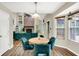 Cozy breakfast nook features a wood table and teal chairs under a pendant light fixture, complemented by backyard views at 7720 Langwood Dr, Indianapolis, IN 46268