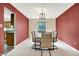 Bright dining room featuring neutral carpet, an elegant light fixture, and views of the adjacent kitchen at 7720 Langwood Dr, Indianapolis, IN 46268