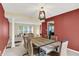 Elegant dining room with a modern light fixture, wood table, upholstered chairs, and an open view to living spaces at 7720 Langwood Dr, Indianapolis, IN 46268