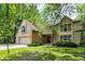 Two story home showcasing a well-manicured lawn, a two-car garage, and mature trees providing natural shade at 7720 Langwood Dr, Indianapolis, IN 46268