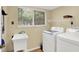 Well-equipped laundry room with modern washer, dryer, utility sink and large window at 7720 Langwood Dr, Indianapolis, IN 46268