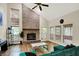 Bright living room features vaulted ceilings, brick fireplace, wood floors, and large windows at 7720 Langwood Dr, Indianapolis, IN 46268