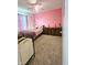 A charming bedroom with pink walls, a dresser, and a laundry hamper at 7906 States Bend Ln, Indianapolis, IN 46239