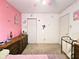 A cozy bedroom featuring pink and white walls, a dresser, and a laundry hamper at 7906 States Bend Ln, Indianapolis, IN 46239