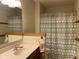 Bathroom with single sink vanity, decorative mirror, and shower tub with patterned curtain at 806 S Jefferson St, Brownsburg, IN 46112