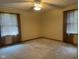 Bedroom with neutral carpet, walls, ceiling fan, and windows with curtains at 806 S Jefferson St, Brownsburg, IN 46112