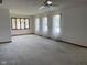 Spacious living room with carpet, light walls, ceiling fan, and multiple windows with sheer curtains at 806 S Jefferson St, Brownsburg, IN 46112
