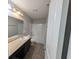 Modern bathroom with a vanity, mirror, and a shower-tub combination with a glass door at 8415 Fieldfare Way, Indianapolis, IN 46237
