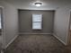 Empty bedroom featuring plush carpet, neutral paint, and a bright window to let in natural light at 8415 Fieldfare Way, Indianapolis, IN 46237