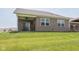Brick home exterior featuring a covered patio with outdoor seating, and a well-kept lawn at 8842 Twain Ln, Indianapolis, IN 46239