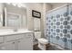 Neutral bathroom featuring a shower with a blue patterned curtain, white vanity, and mirror at 8842 Twain Ln, Indianapolis, IN 46239