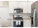 Kitchen featuring white cabinets, stainless steel appliances, and a subway tile backsplash at 8842 Twain Ln, Indianapolis, IN 46239