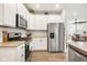 Well-equipped kitchen with stainless steel appliances, white cabinets, and a view to the living room at 8842 Twain Ln, Indianapolis, IN 46239