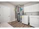 Functional laundry room with white washer, dryer, cabinets, and energy-efficient water heater system at 8842 Twain Ln, Indianapolis, IN 46239
