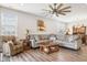 Bright living room with a large sectional sofa, ceiling fan, and wood-look flooring at 8842 Twain Ln, Indianapolis, IN 46239