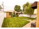 Charming backyard featuring a well-kept lawn, a gazebo, and a quaint brick structure with green trim at 972 N Audubon Rd, Indianapolis, IN 46219