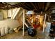 Unfinished basement space with exposed ceiling, wooden stairs, storage, and a glimpse of potential at 972 N Audubon Rd, Indianapolis, IN 46219
