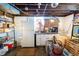 Basement area includes a vintage refrigerator, compact kitchenette and open ceiling with exposed ductwork at 972 N Audubon Rd, Indianapolis, IN 46219