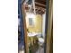 Small basement bathroom featuring a pedestal sink, standard toilet, and a glimpse of exposed infrastructure at 972 N Audubon Rd, Indianapolis, IN 46219