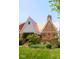 Well-maintained brick home with a unique roof, covered porch, and beautifully landscaped garden area at 972 N Audubon Rd, Indianapolis, IN 46219