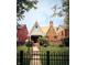 Charming brick home with a peaked roof, manicured lawn, and black wrought iron fence at 972 N Audubon Rd, Indianapolis, IN 46219