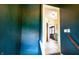 Hallway with striking dark blue walls and an open doorway offering a view into a warmly lit interior space at 972 N Audubon Rd, Indianapolis, IN 46219