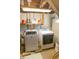 Functional laundry room equipped with a washer and dryer, shelving, and essential cleaning supplies at 972 N Audubon Rd, Indianapolis, IN 46219