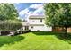 Large backyard with green lawn, mature trees, and manicured shrubbery at 9740 Logan Ln, Fishers, IN 46037