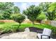 Serene backyard featuring a brick patio, verdant lawn, privacy fence, and manicured landscaping at 9740 Logan Ln, Fishers, IN 46037