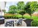 Backyard featuring a brick patio with outdoor seating, lush greenery, and a wood fence at 9740 Logan Ln, Fishers, IN 46037