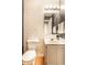 Charming half bathroom with a white vanity, decorative wallpaper, and modern fixtures at 9740 Logan Ln, Fishers, IN 46037