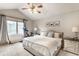 Bright bedroom with a large window, ceiling fan, and a modern exercise bike at 9740 Logan Ln, Fishers, IN 46037