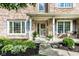 Charming brick home entrance with gray shutters, decorative plants, and a welcoming porch at 9740 Logan Ln, Fishers, IN 46037