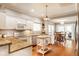 Bright kitchen with an open layout, featuring white cabinets, stainless appliances, and hardwood floors at 9740 Logan Ln, Fishers, IN 46037